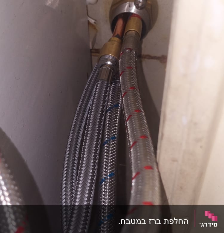 צינורות מתכת מחוברים לקיר עם מחברים